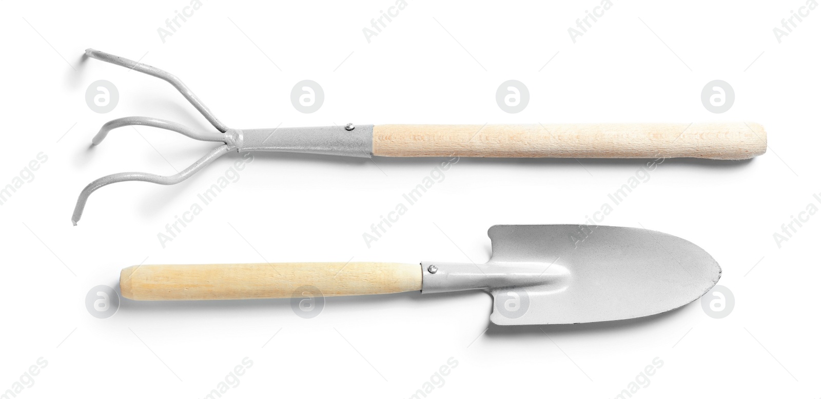 Photo of New rake and trowel on white background. Professional gardening tools