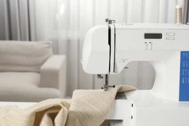 Photo of White sewing machine and fabric indoors, closeup