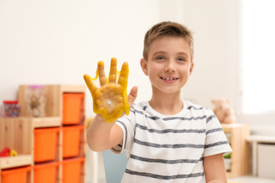 Photo of Little boy with slime in playroom, focus on hand
