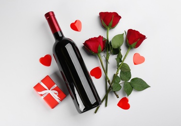 Photo of Flat lay composition with gift box and roses on white background. Valentine's Day celebration