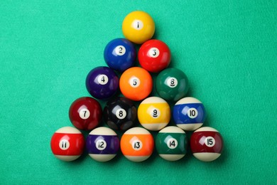 Photo of Set of billiard balls on green table, flat lay