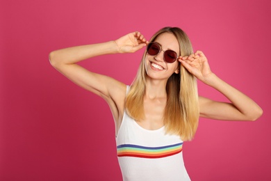 Photo of Beautiful woman in stylish sunglasses on pink background