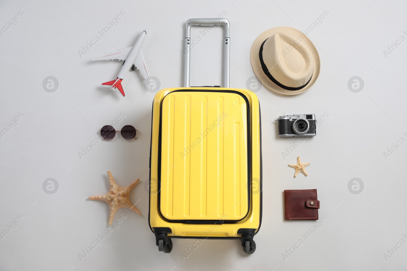 Photo of Flat lay composition with suitcase and travel accessories on grey background. Summer vacation