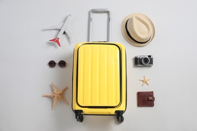 Photo of Flat lay composition with suitcase and travel accessories on grey background. Summer vacation