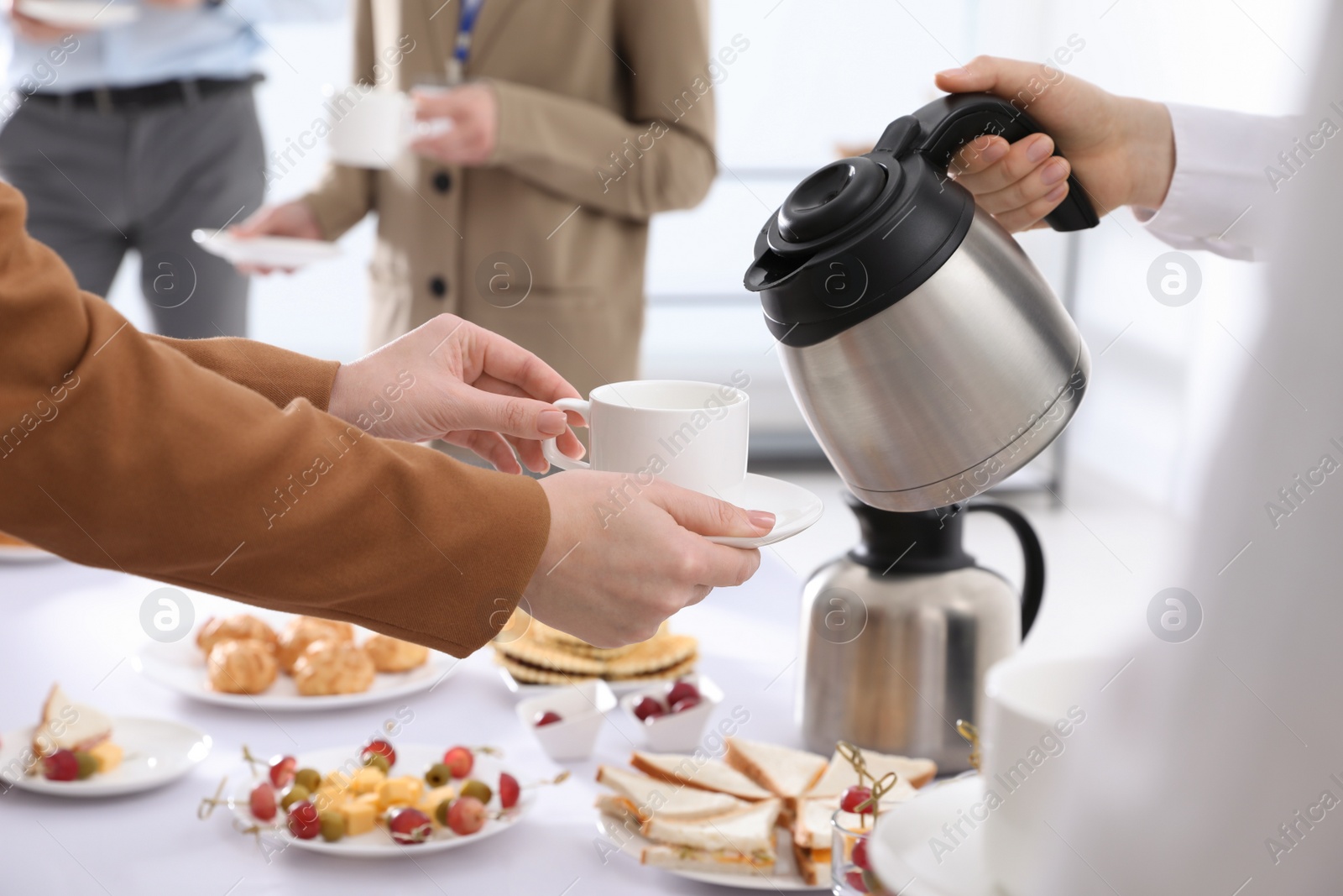 Photo of Waitress pouring hot drink during coffee break, closeup