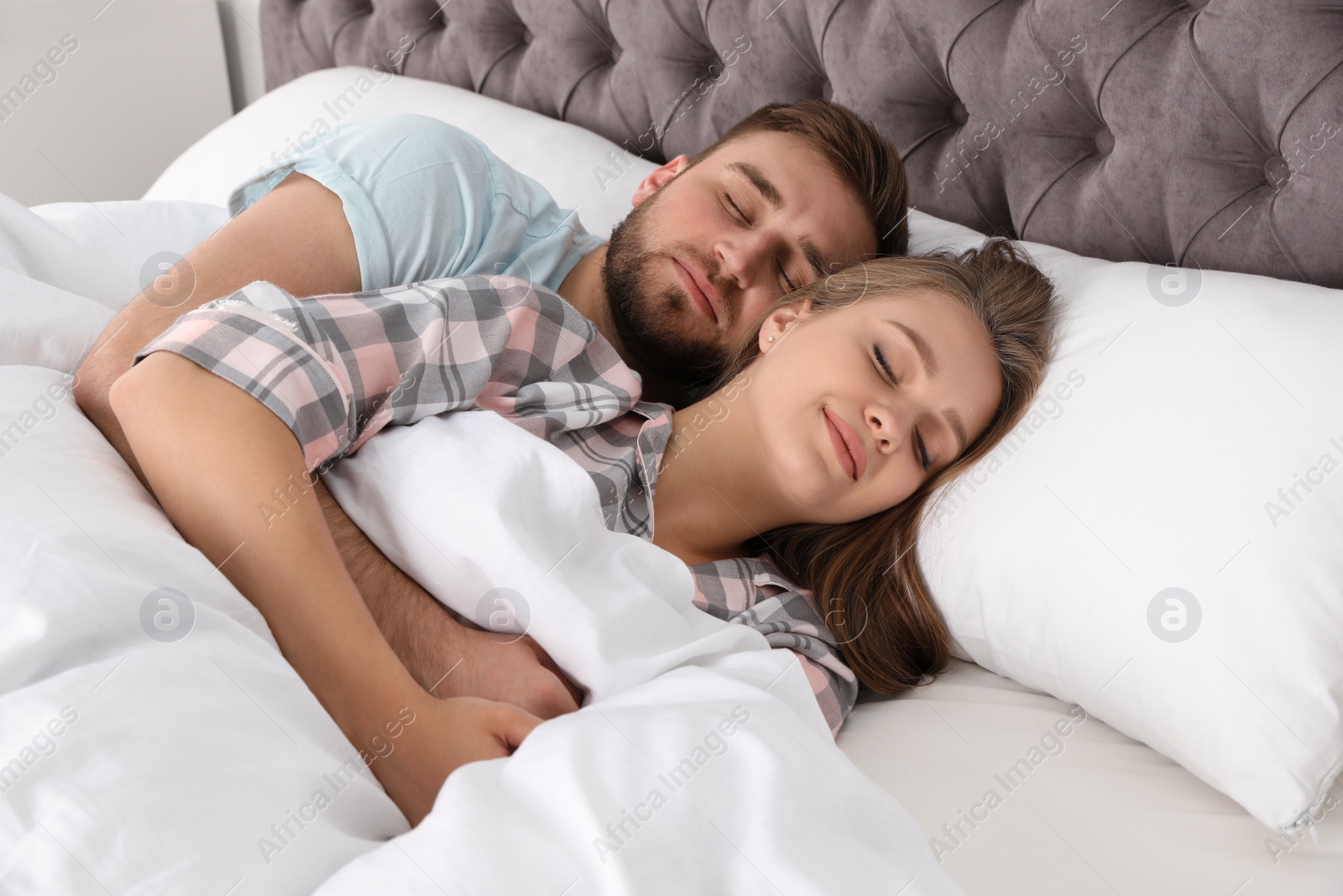 Photo of Young couple sleeping together in bed at home