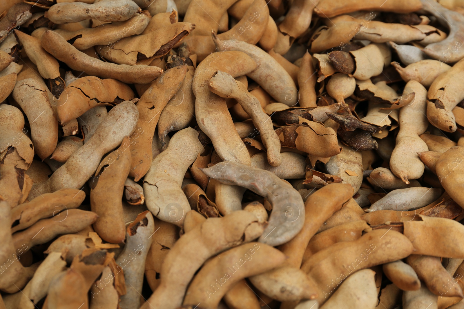 Photo of Pile of ripe tamarind fruits as background, closeup