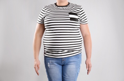 Photo of Fat woman on grey background, closeup. Weight loss