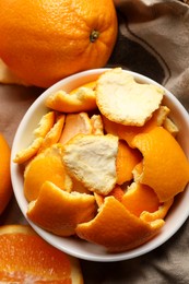 Photo of Orange peels preparing for drying and fresh fruits on cloth, flat lay