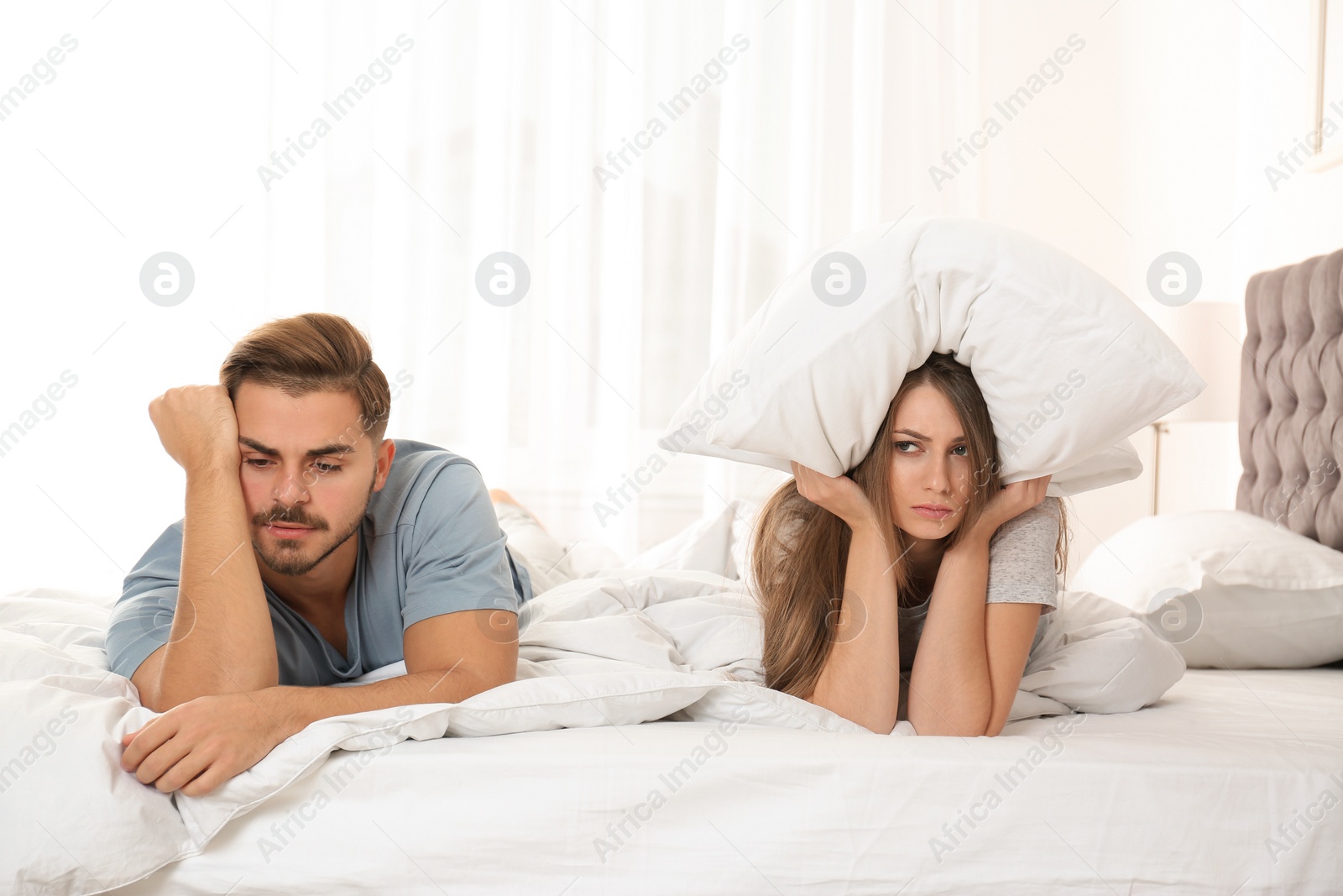 Photo of Upset young couple with relationship problems in bedroom