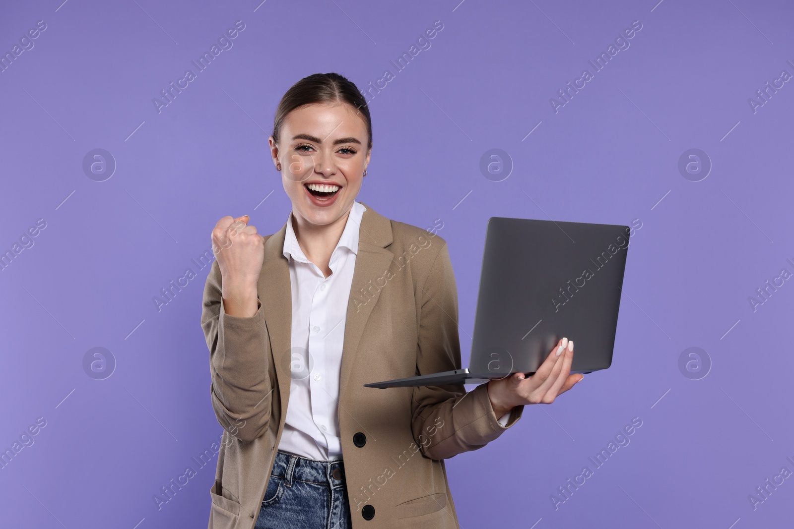 Photo of Happy woman with laptop on violet background
