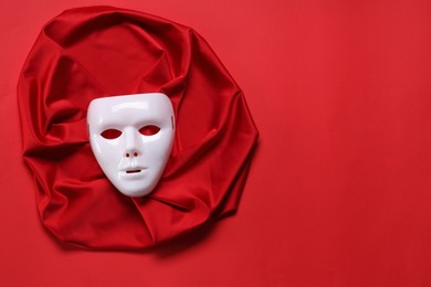 Theater arts. White mask and fabric on red background, top view. Space for text