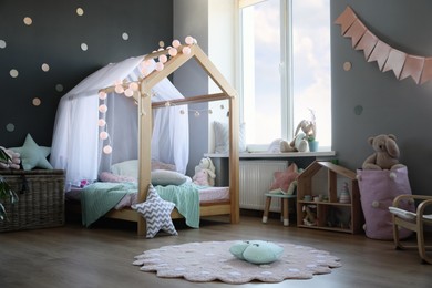 Photo of Stylish child room interior with house bed and different toys