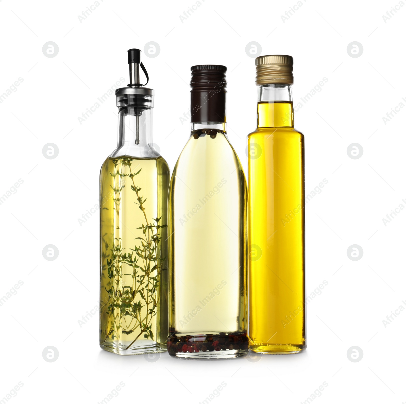 Photo of Different sorts of cooking oil in bottles isolated on white