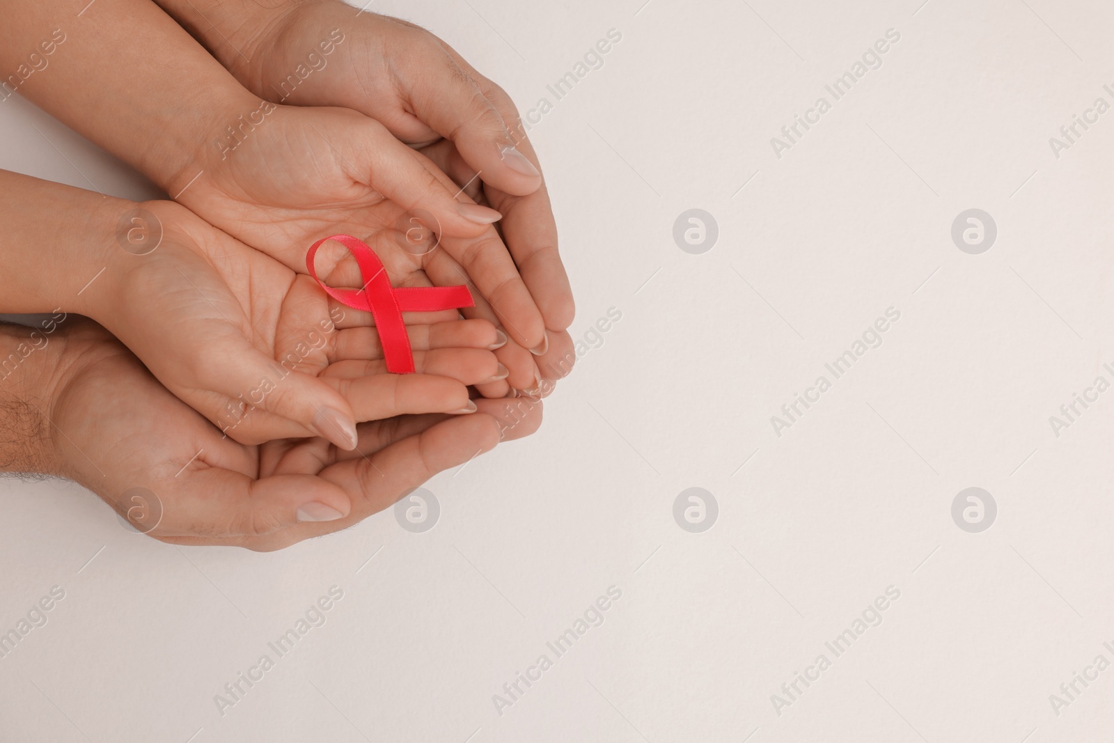 Photo of Couple holding pink ribbon on white background, top view with space for text. Breast cancer awareness