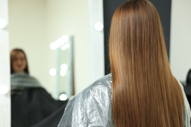 Woman with straight hair in beauty salon, back view
