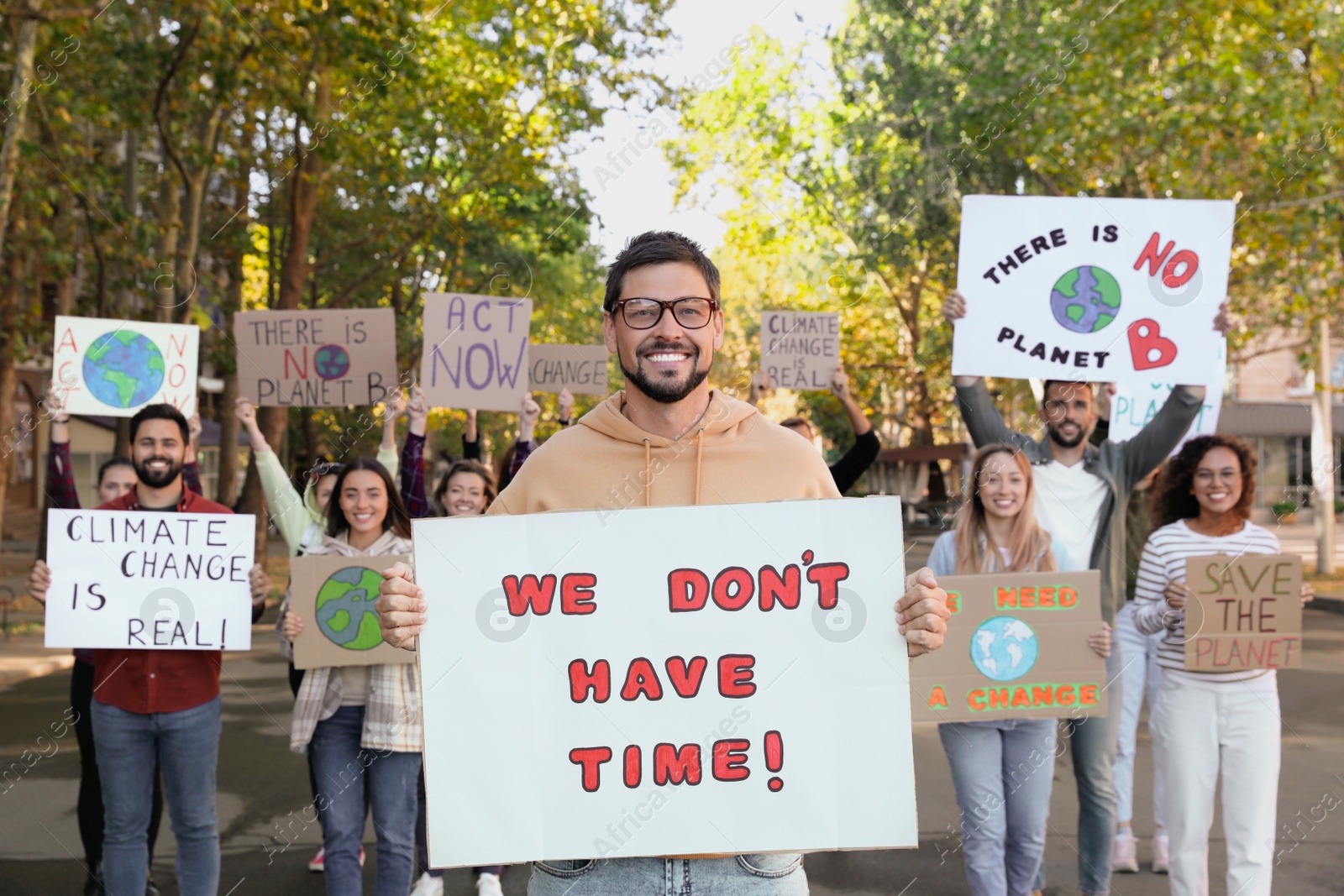 Photo of Group of people with posters protesting against climate change on city street