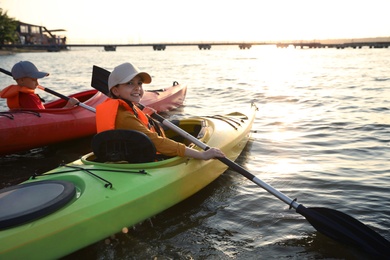 Little children kayaking on river. Summer camp activity