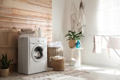 Photo of Stylish room interior with modern washing machine