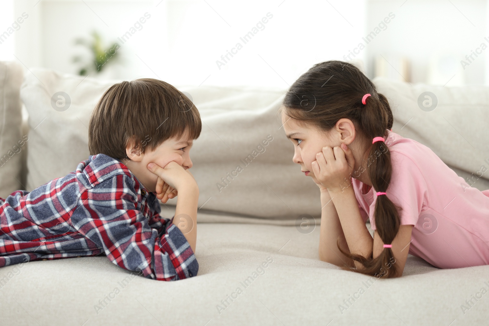 Photo of Upset brother and sister on sofa at home