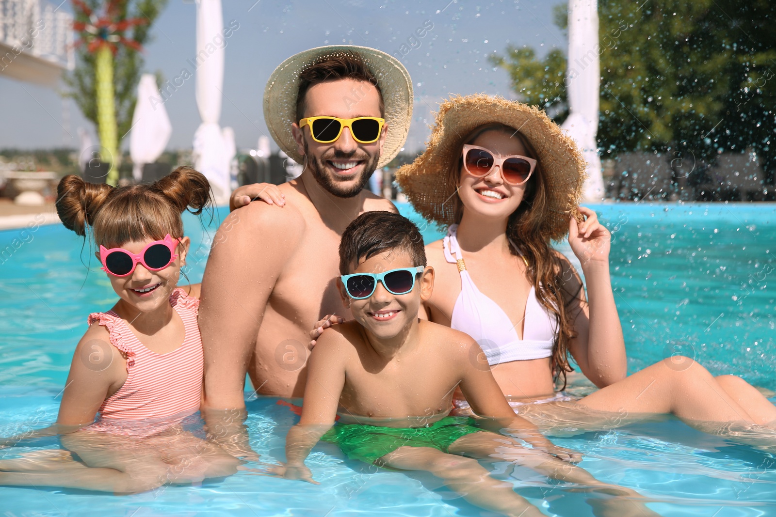 Photo of Happy family in swimming pool on sunny day