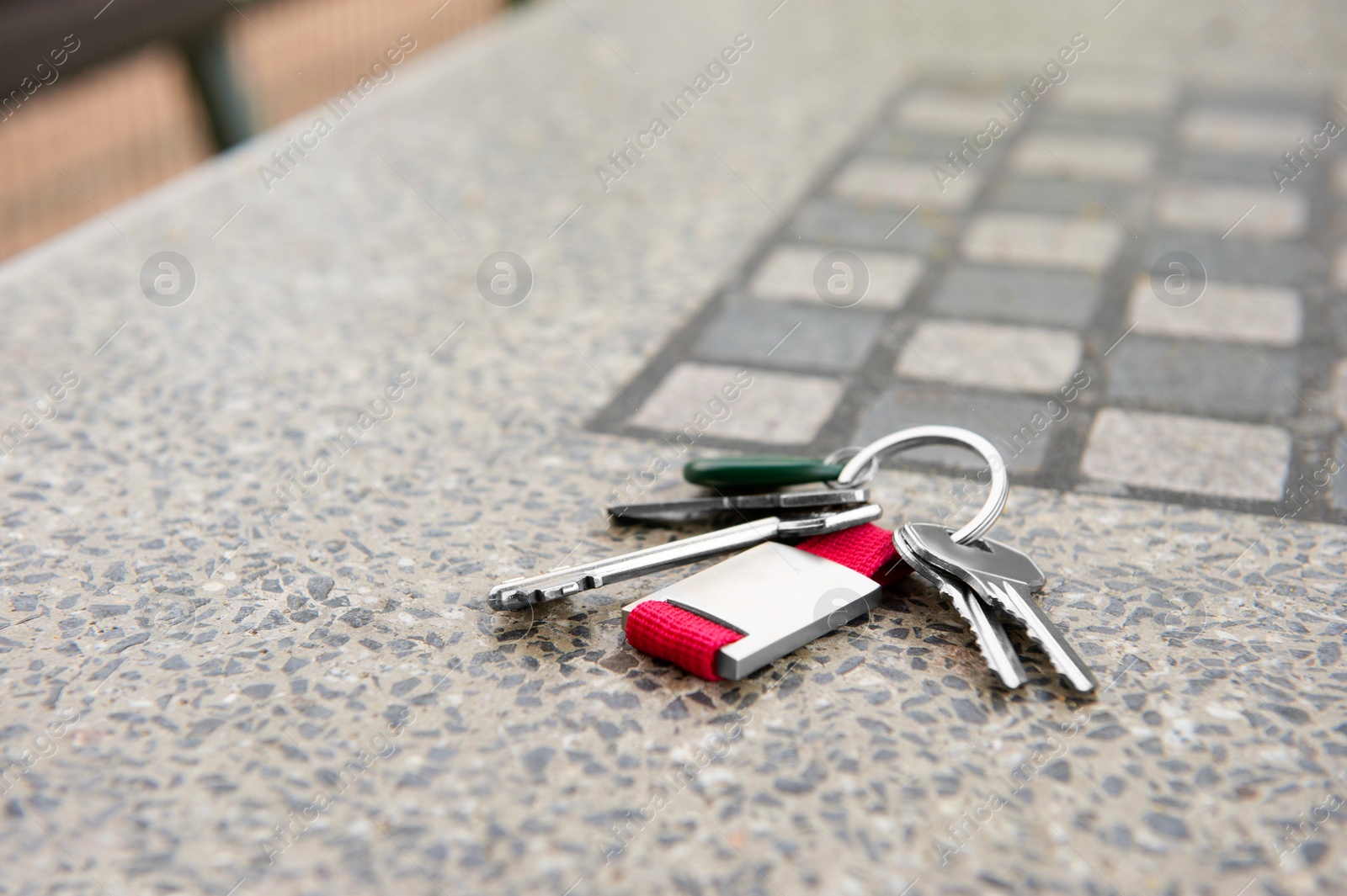 Photo of Keys forgotten on grey stone table outdoors. Space for text. Lost and found