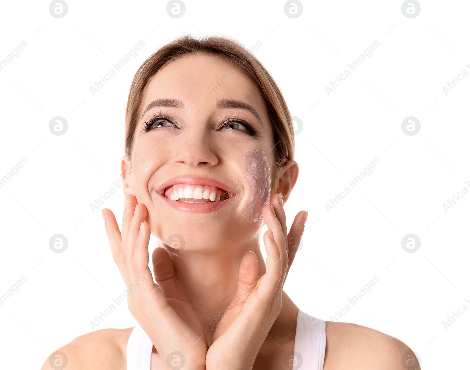 Photo of Young woman applying natural scrub on her face against white background