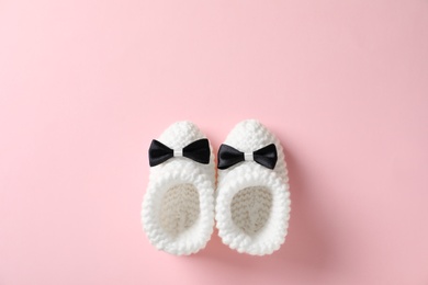 Handmade baby booties on color background, top view with space for text