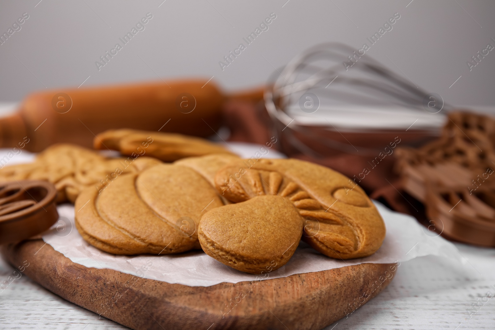 Photo of Tasty cookies and cutters on white wooden table, closeup