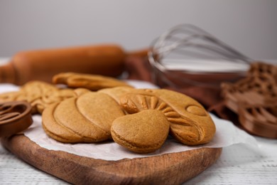 Photo of Tasty cookies and cutters on white wooden table, closeup