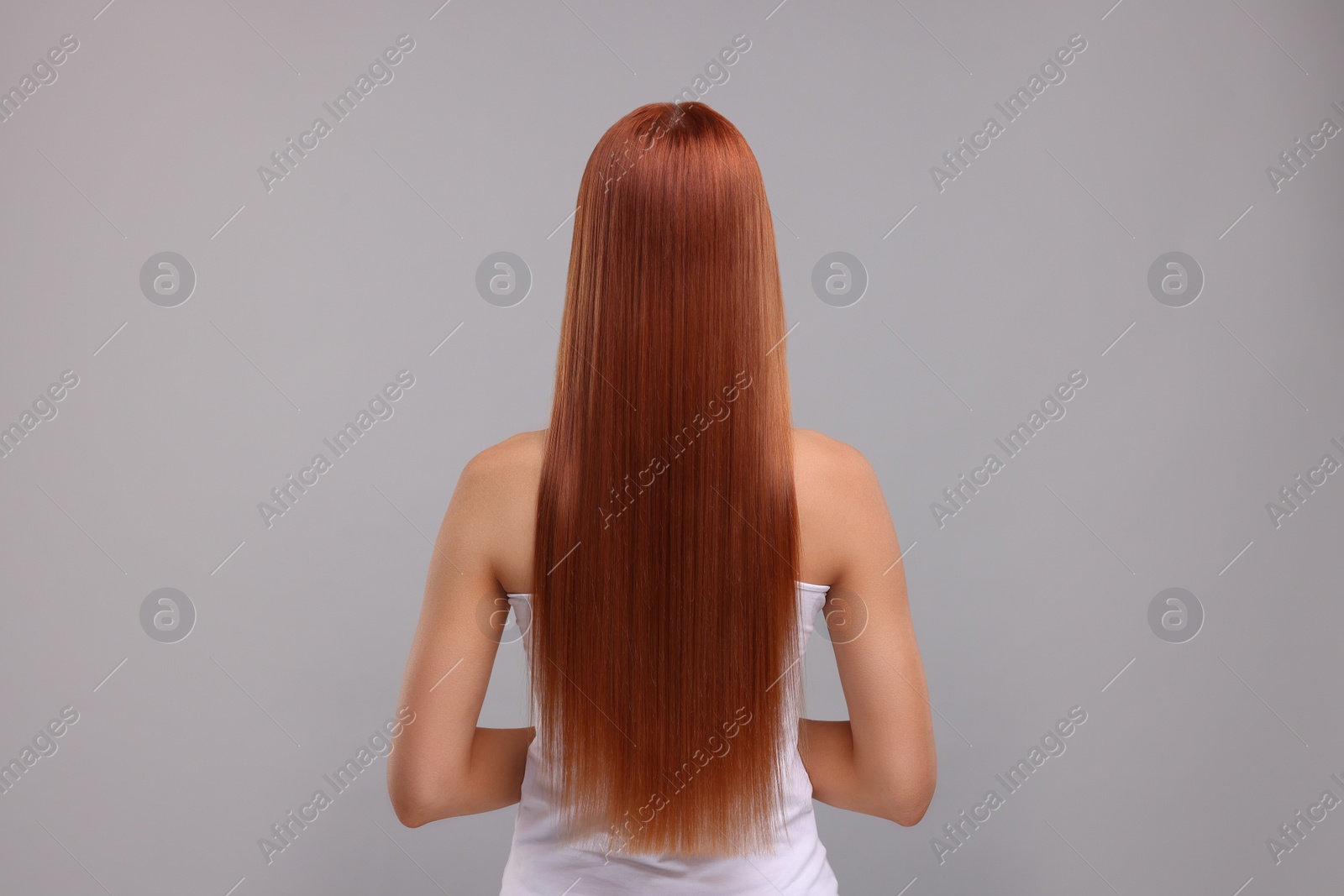 Photo of Woman with healthy hair after treatment on light grey background, back view