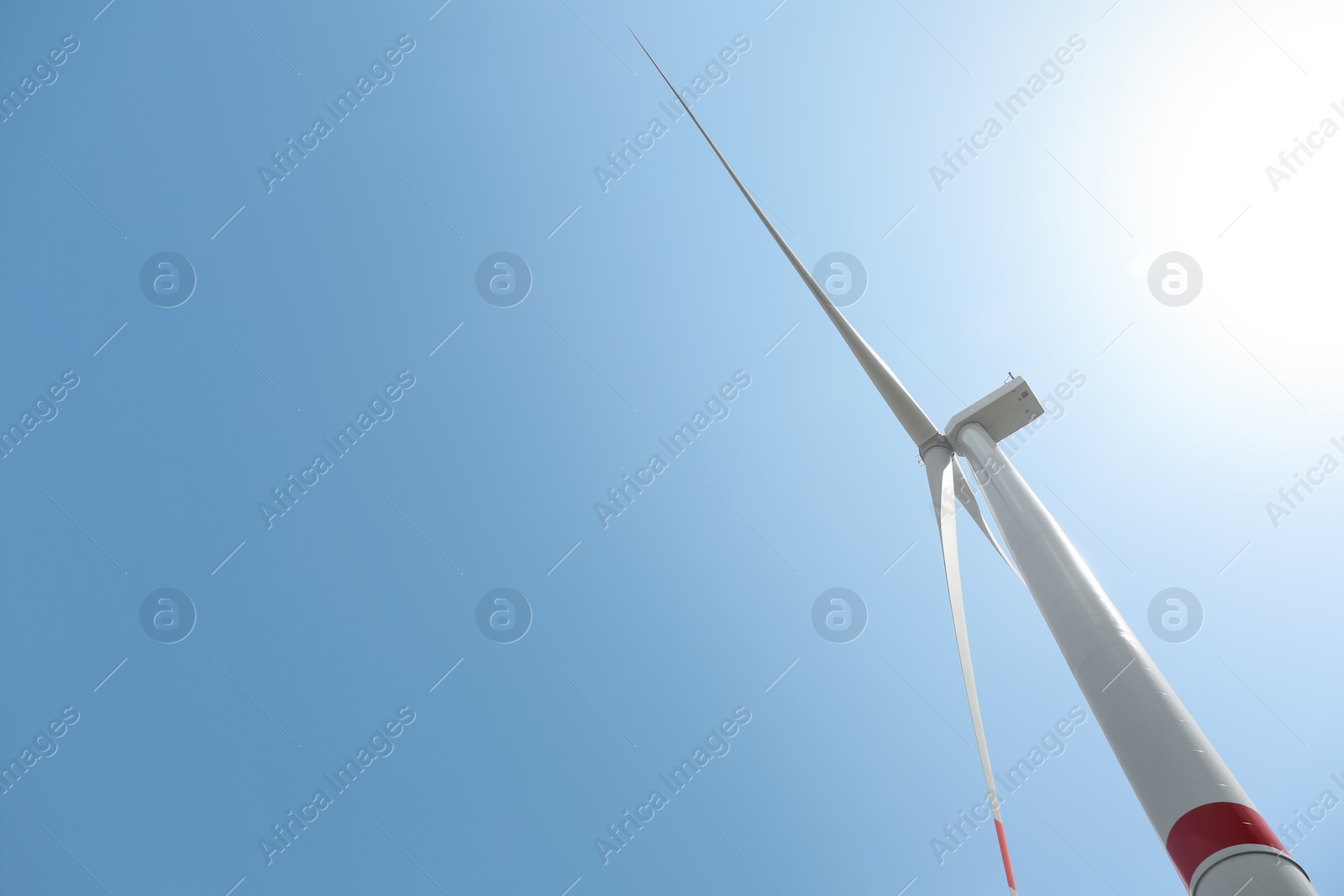 Photo of Modern wind turbine against blue sky, low angle view. Energy efficiency