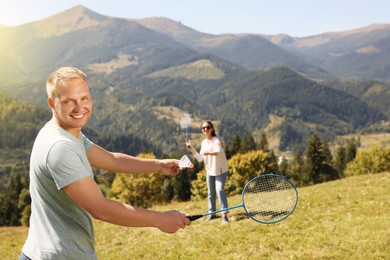 Photo of Couple playing badminton in mountains on sunny day