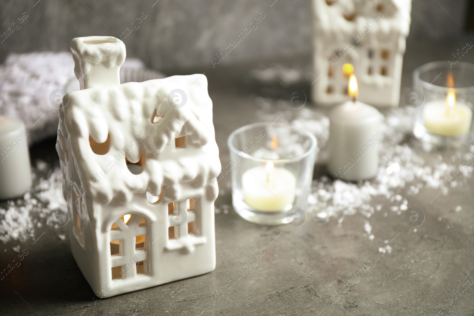 Photo of Composition with house shaped candle holders on grey stone table. Christmas decoration