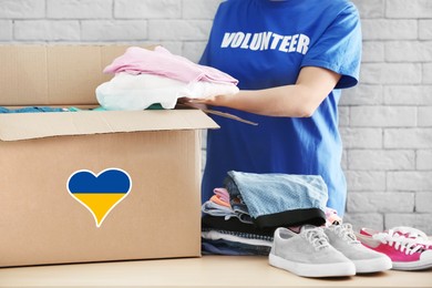 Image of Humanitarian aid for Ukrainian refugees. Volunteer putting clothes into donation box indoors, closeup