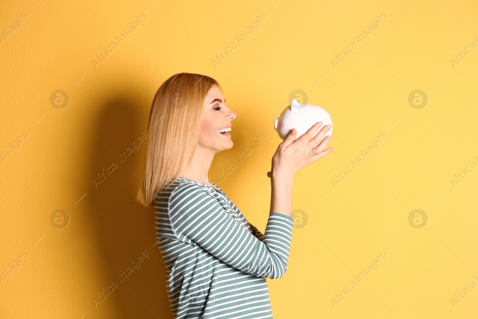 Photo of Woman with piggy bank on color background