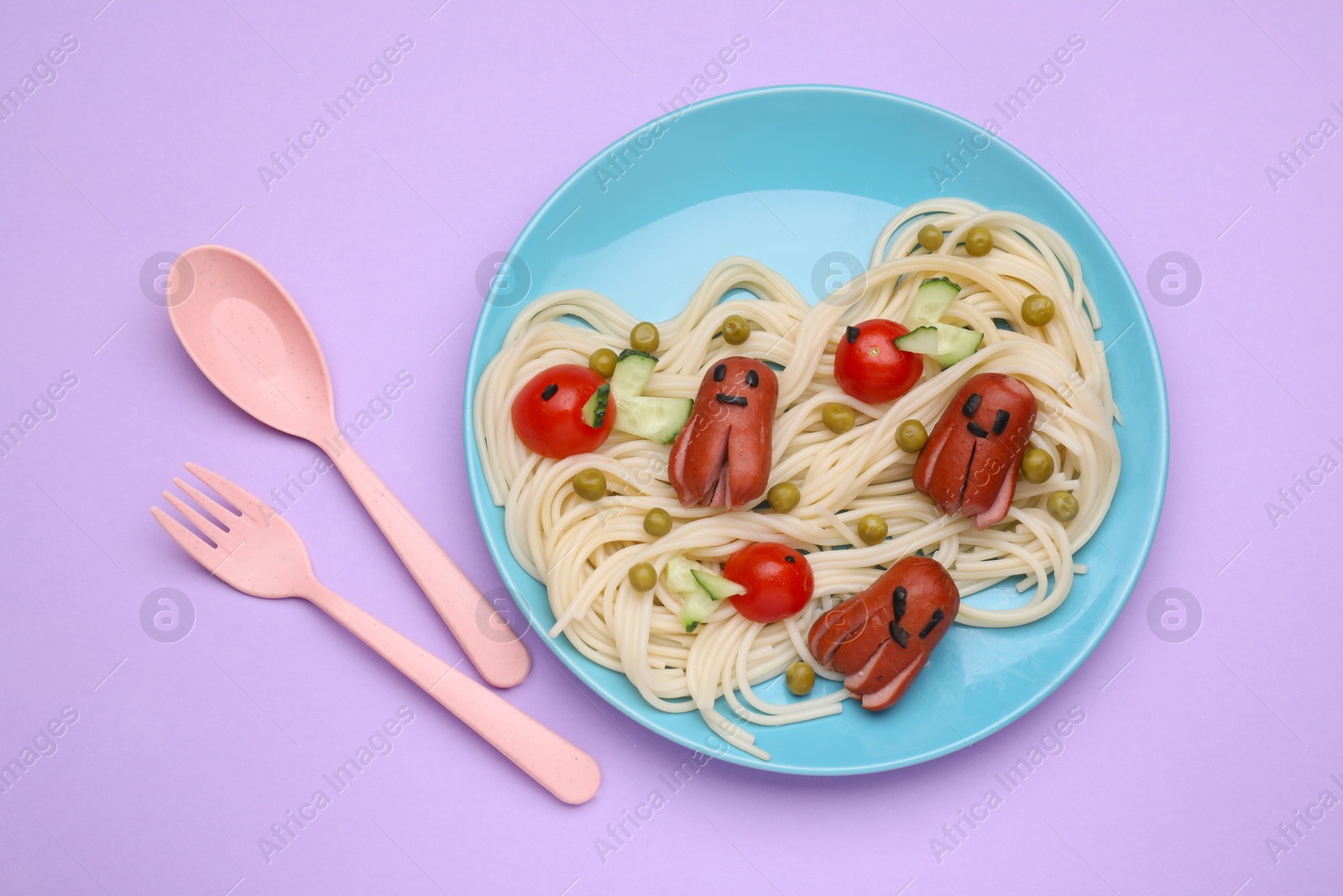 Photo of Creative serving for kids. Plate with cute octopuses made of sausages, pasta and vegetables on violet table, flat lay
