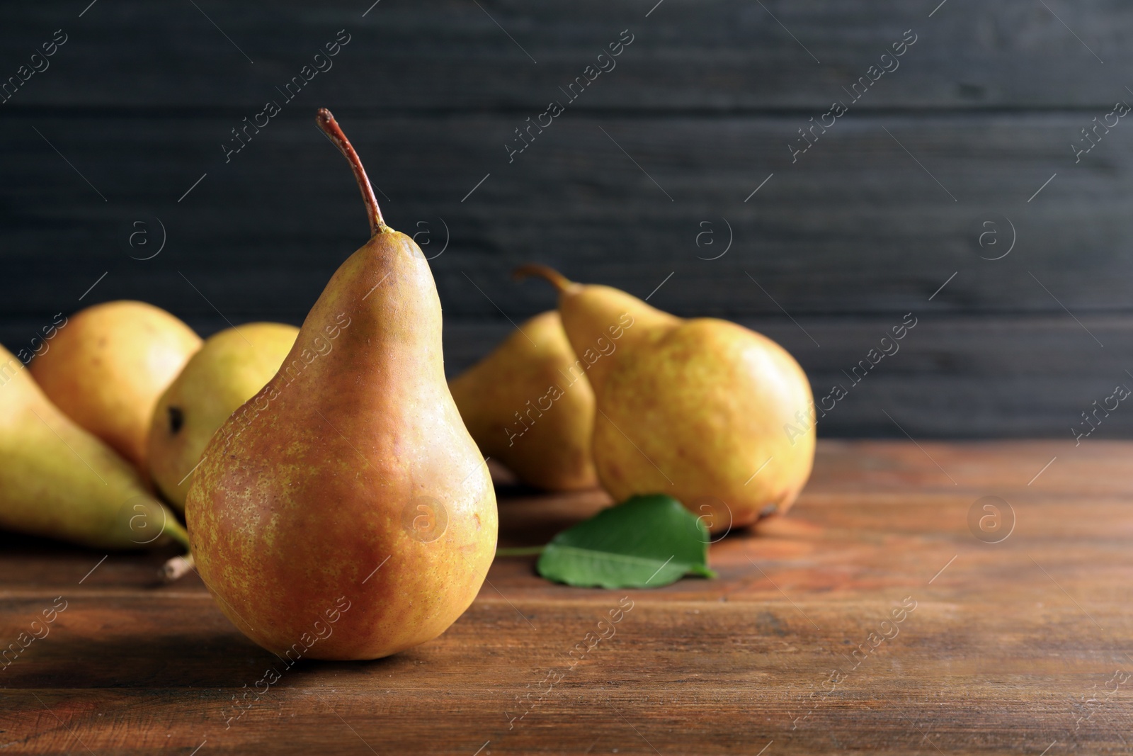 Photo of Ripe pear on wooden table. Space for text