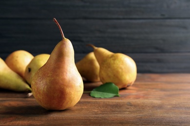 Photo of Ripe pear on wooden table. Space for text