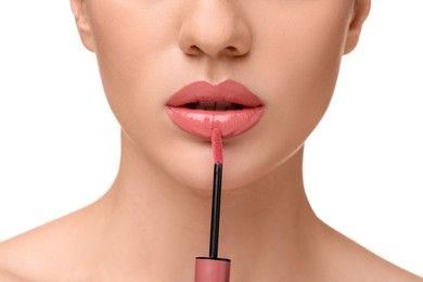 Photo of Woman applying lip gloss on white background, closeup
