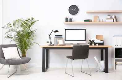 Photo of Modern computer on table in office interior. Stylish workplace