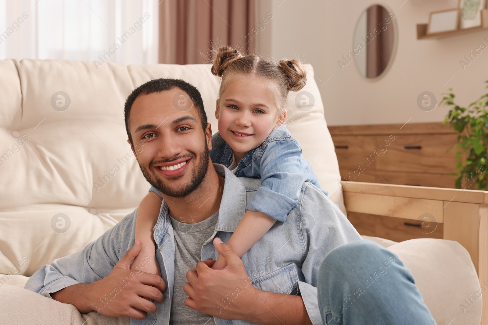 Photo of Little girl with her father spending time together at home. International family