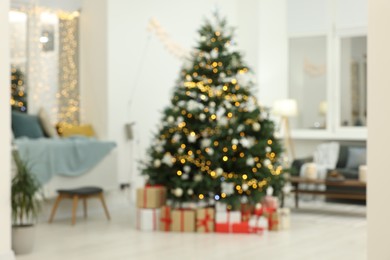 Blurred view of decorated Christmas tree and gift boxes in living room. Interior design