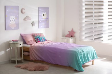 Bed with colorful linen in stylish children's room. Interior design