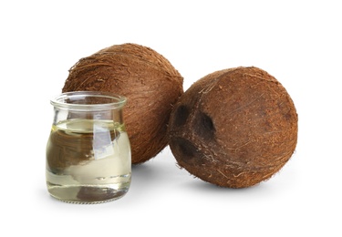 Ripe coconuts and jar with natural organic oil on white background