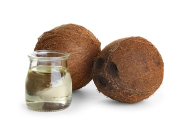 Photo of Ripe coconuts and jar with natural organic oil on white background