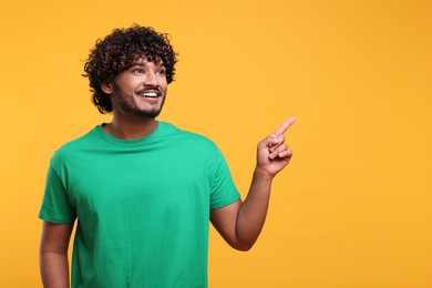 Handsome smiling man on yellow background, space for text