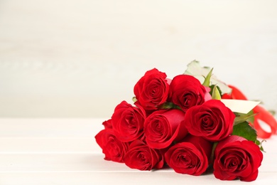 Beautiful red roses on white table, space for text. St. Valentine's day celebration