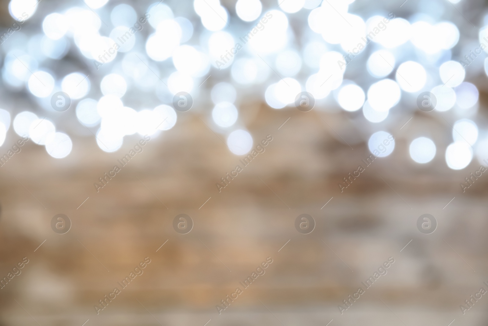 Photo of Blurred view of glowing Christmas lights on color background, top view