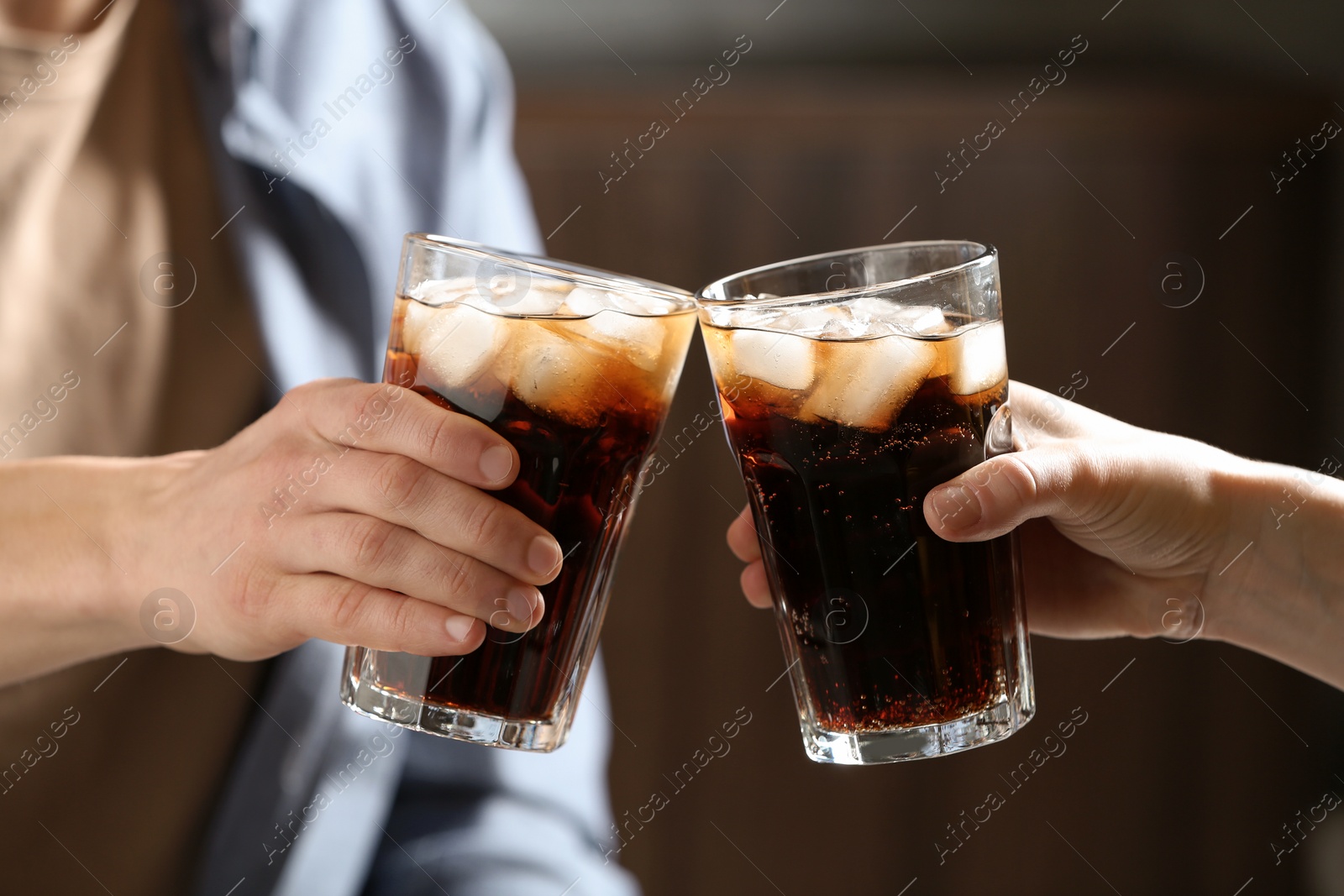 Photo of Couple with glasses of cold cola indoors, closeup